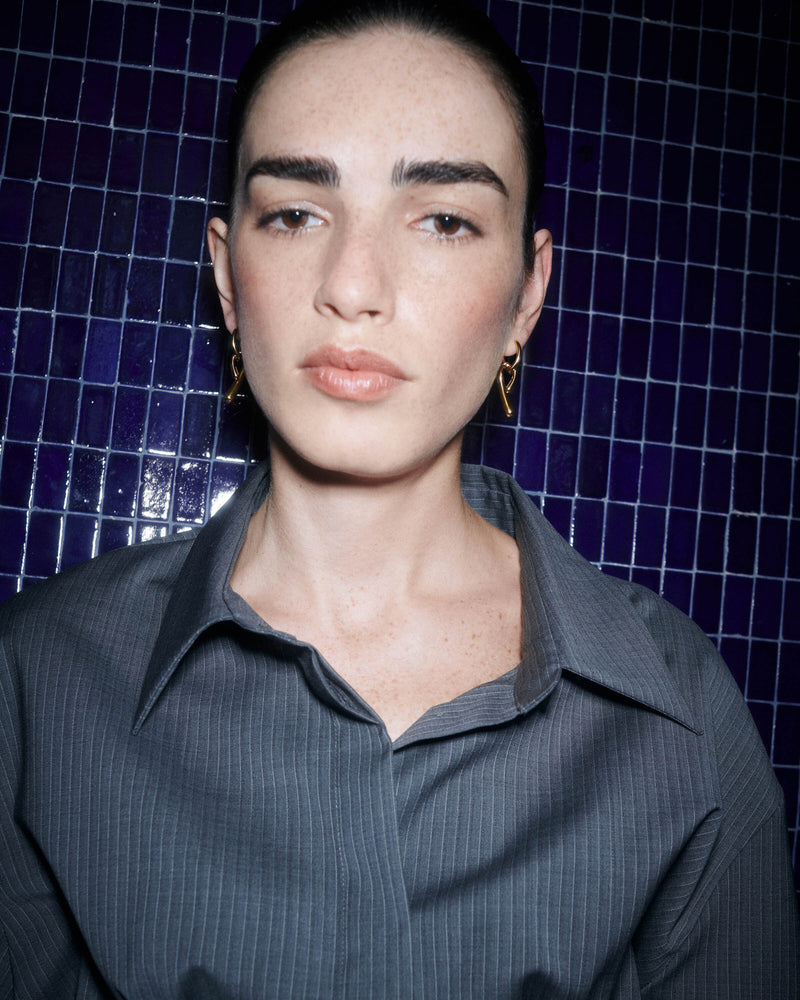 Small asymmetric hoop earrings with fluid knotted pendants