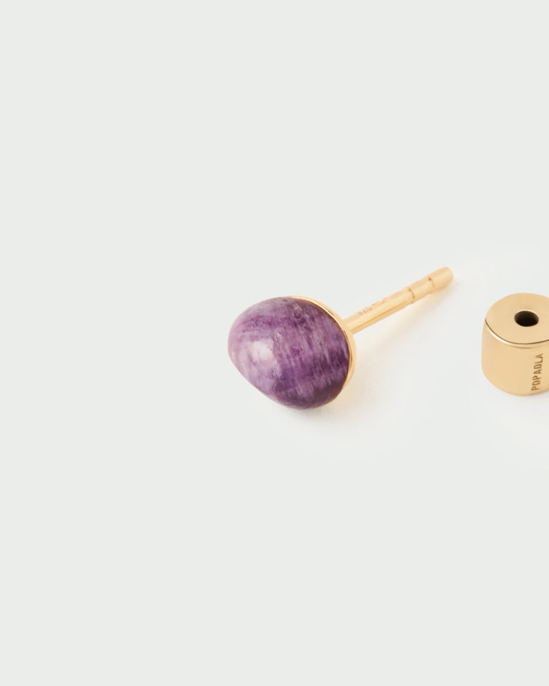 Gold-plated fluid ear piercing with an irregular purple round gemstone