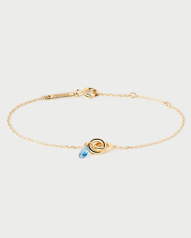 Gold-plated bracelet featuring two interlinked rings with a blue zirconia drop pendant