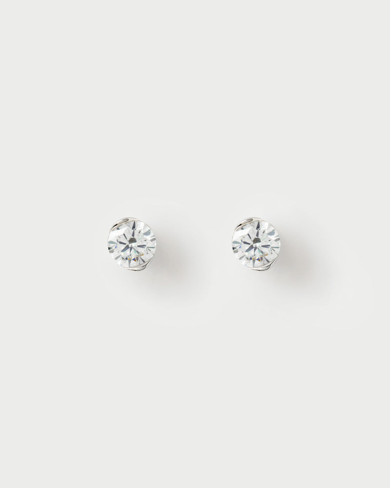 White gold diamond stud earrings with a large round half-bezel lab-grown diamond