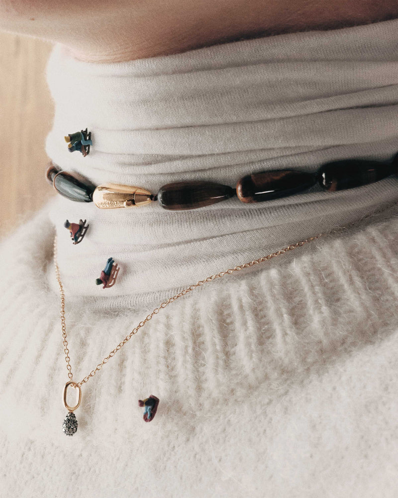 Modern choker featuring brown gemstone beads and signature drop closure
